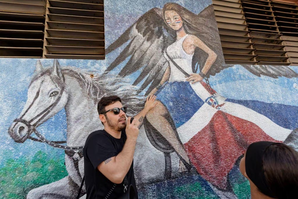 Juan Carlos presentando un mural de Los Pepines con un caballo y una figura alada
